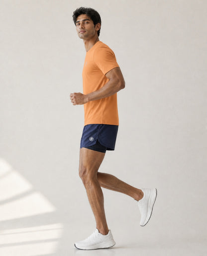 Athleia Sprintlite Shorts Navy with Pro Tee Orange, side view showing liner – worn by a man