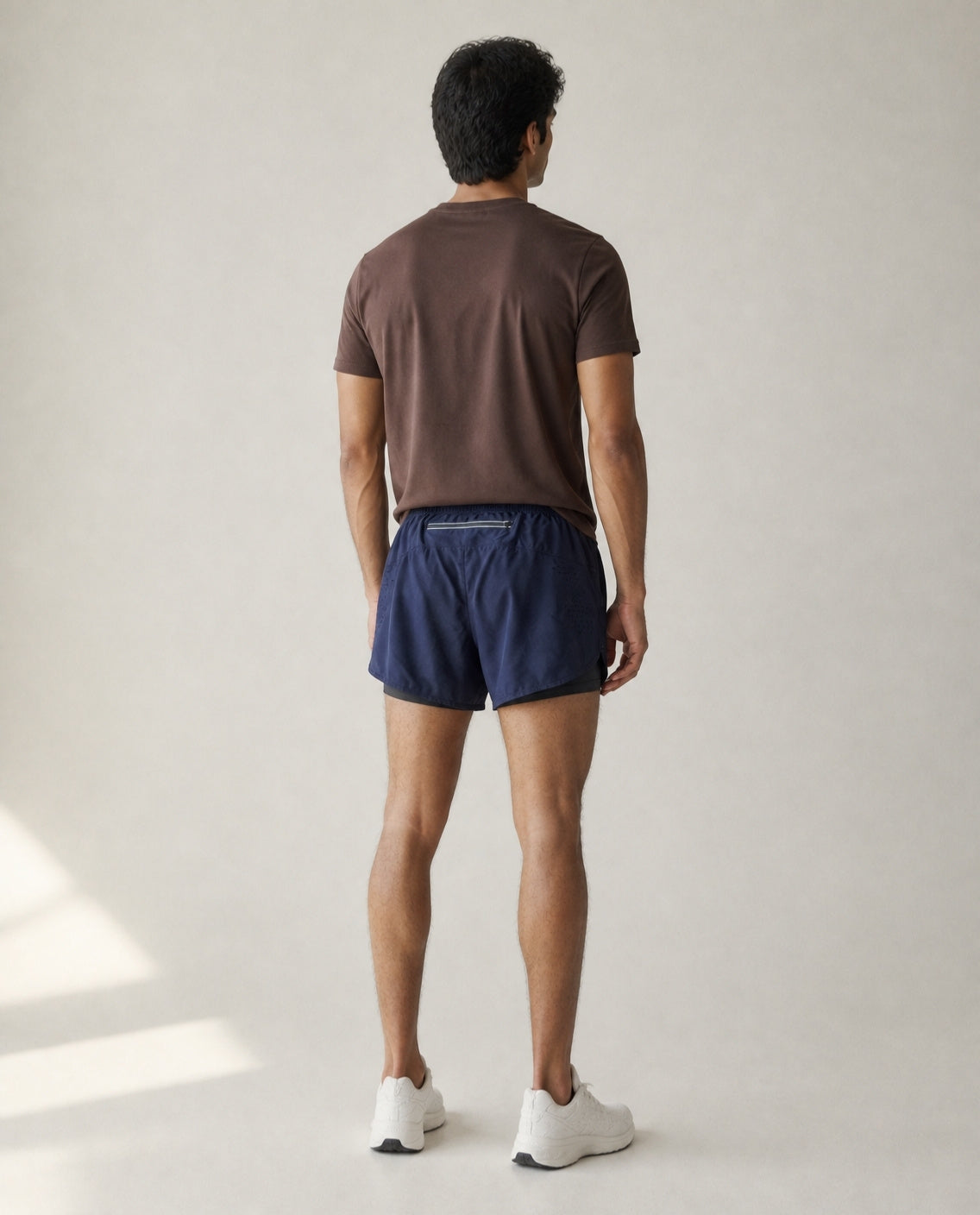 Athleia Sprintlite Shorts Navy with Pro Tee Brown, back view – worn by a man